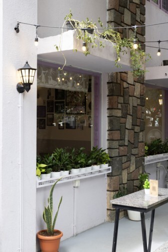 Exterior view of German dining space with potted plants and stone wall accents